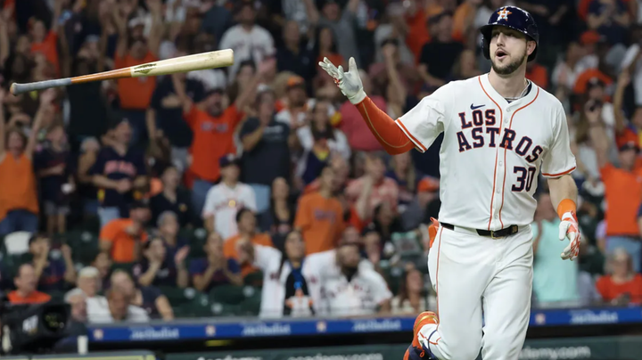 Kyle Tucker flipping a bat after a home run while wearing a "Los Astros" jersey 