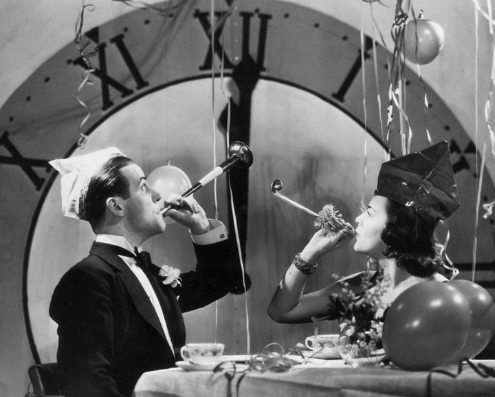 Photo of people celebrating New Year's in formal dress and party hats, circa 1930 or so