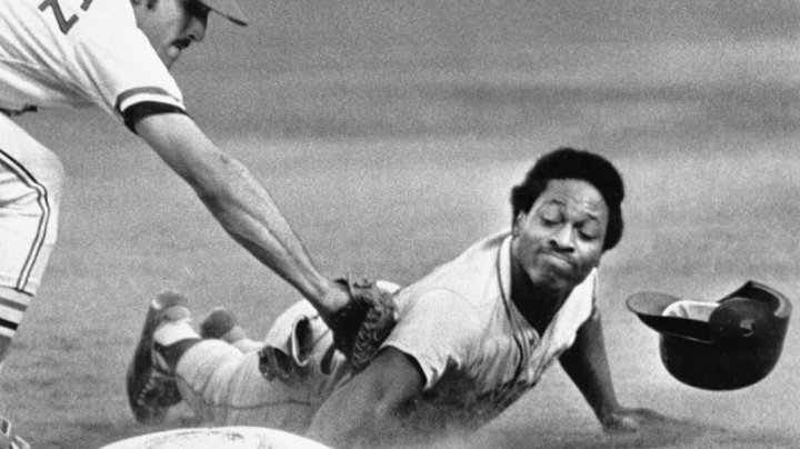 Lenny Randle, sliding back into first base and avoiding a pickoff tag from Keith Hernandez