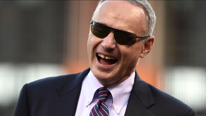 Rob Manfred wearing sunglasses and smiling like a big doof 