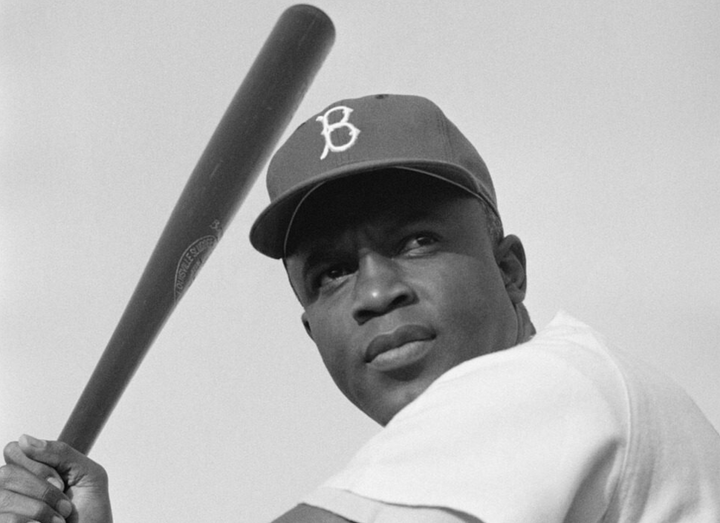 Black and white photo of Jackie Robinson holding a bat 