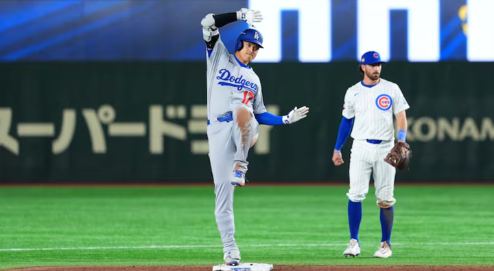 Shohei Ohtani doing the Freddie Freeman dance thing at second base while a Cubs infielder looks on.